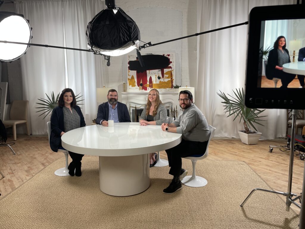 Francesca Lewis-Hatheway, PsyD, Paul Grant, PhD, Ellen Inverso, PsyD, and Adam Rifkin, MA, LPC are sitting around a white table, smiling at the camera.