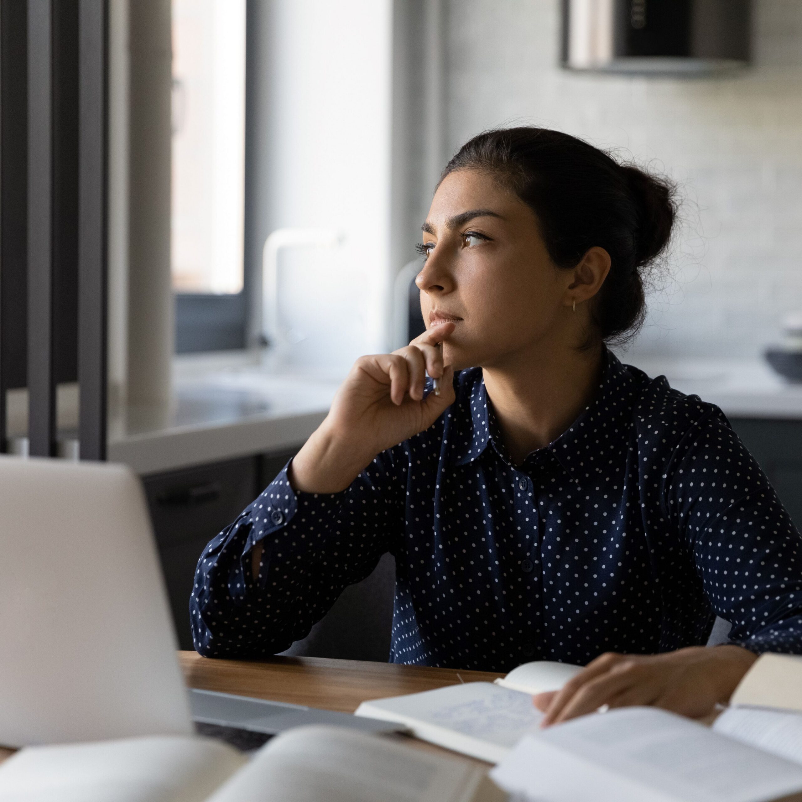 Woman looking at a laptop making a decision.