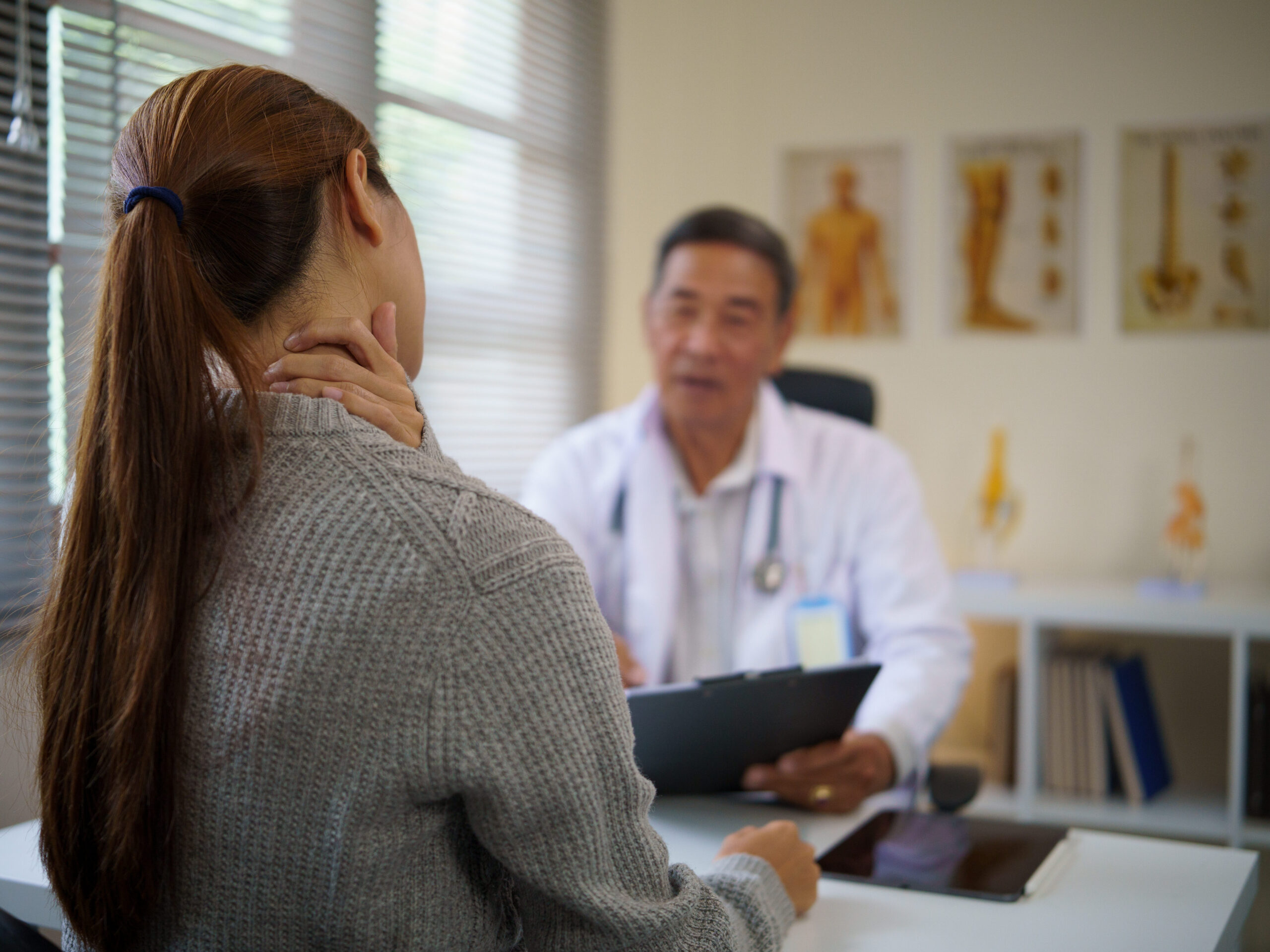 Male doctor meeting with female patient with chronic pain.