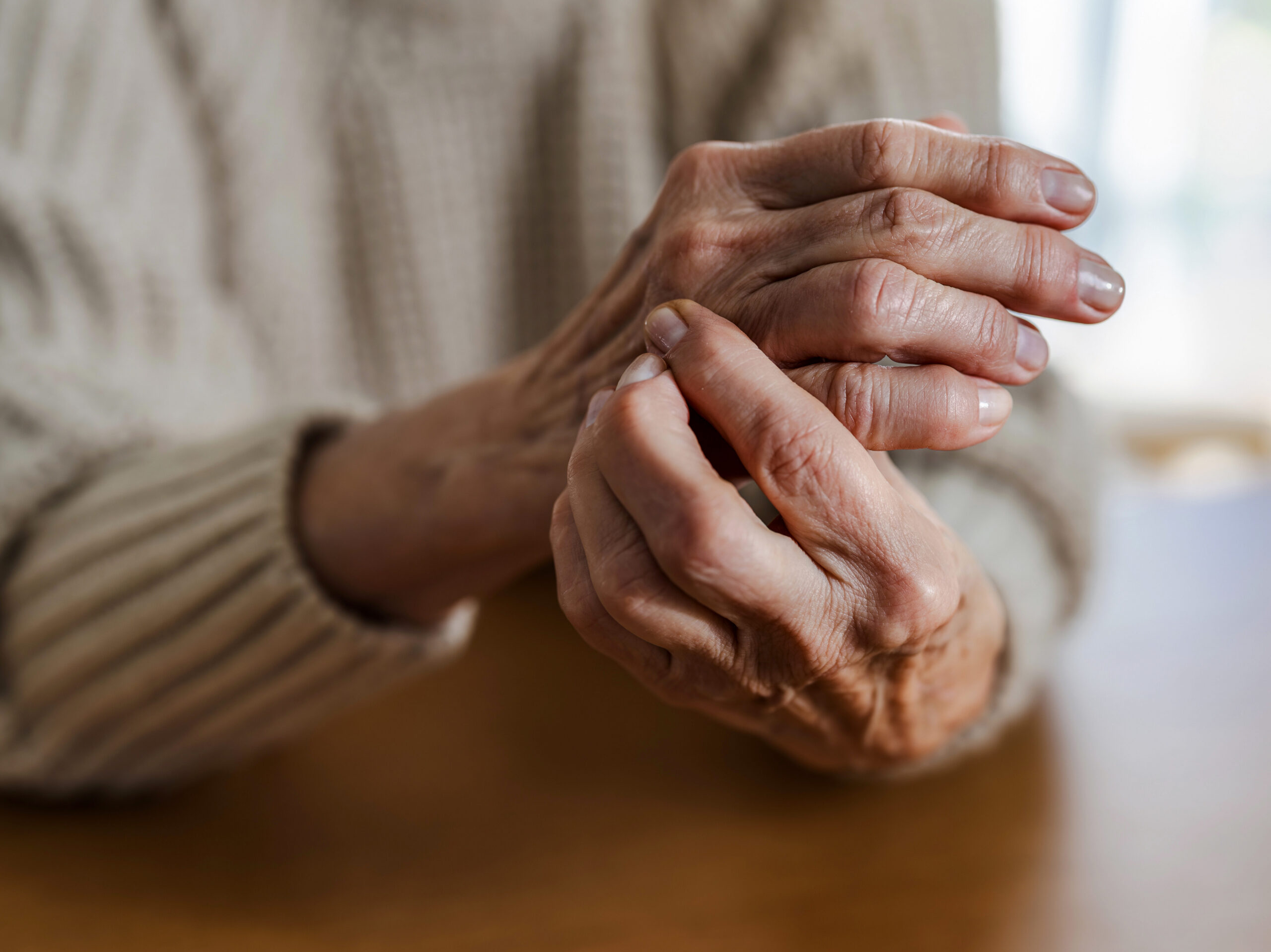 An older person's hands with arthritis pain