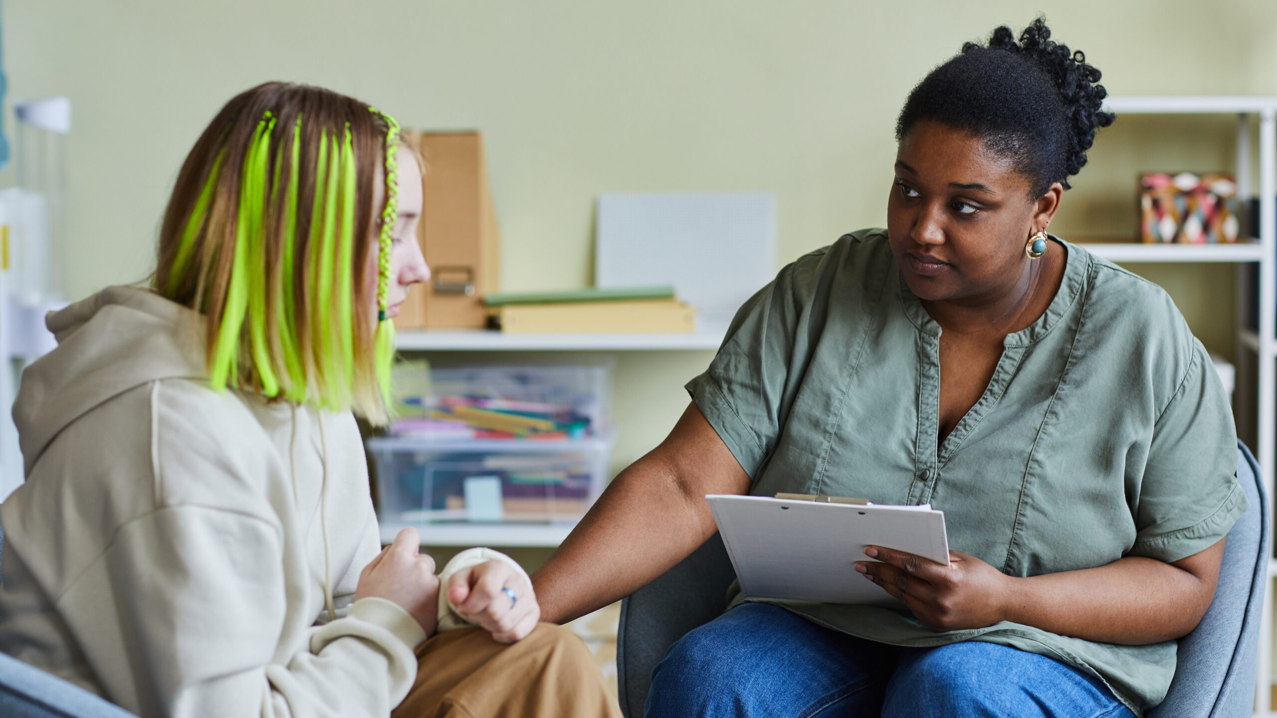 Female mental health counselor works with a teen trauma client