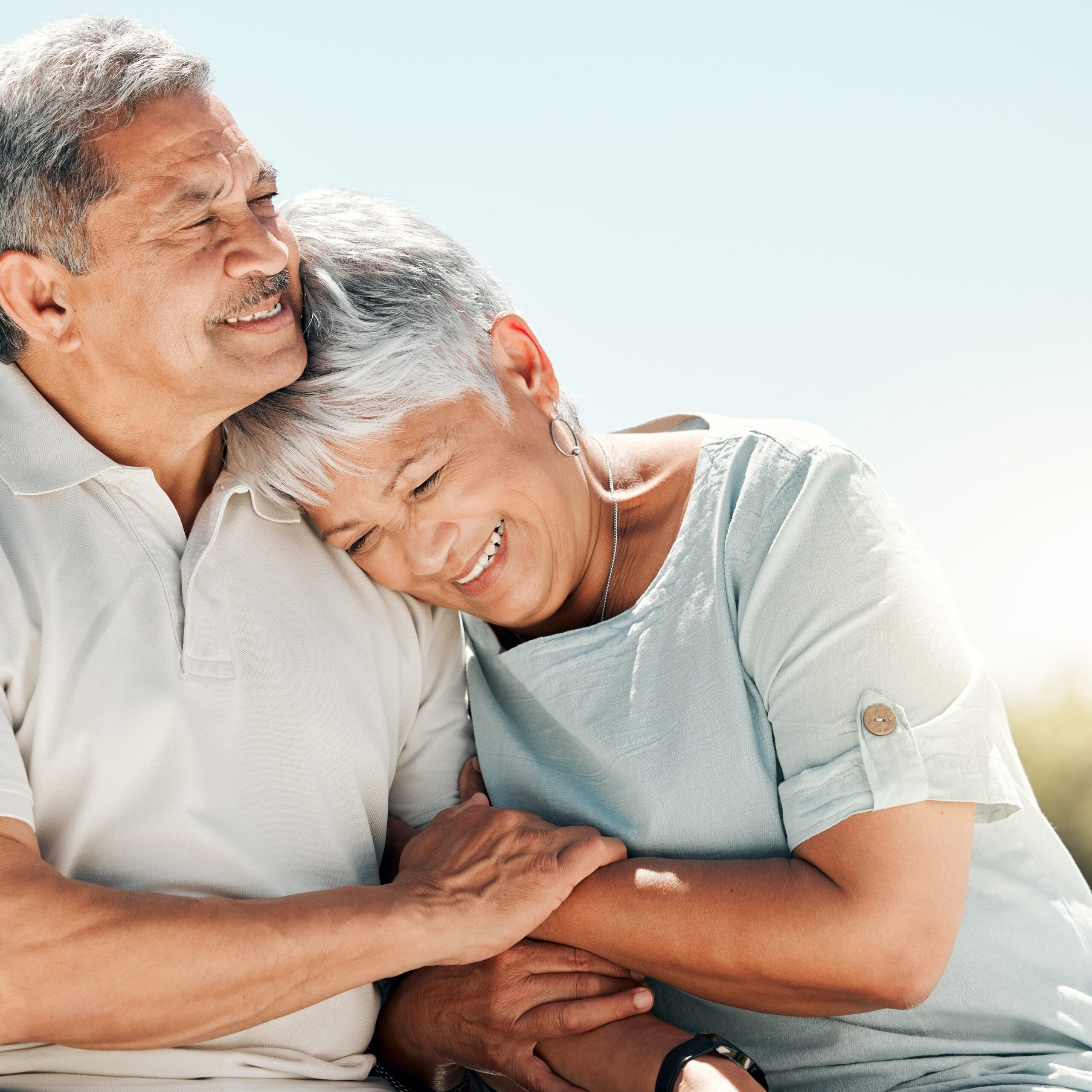 An older woman embraces her husband.