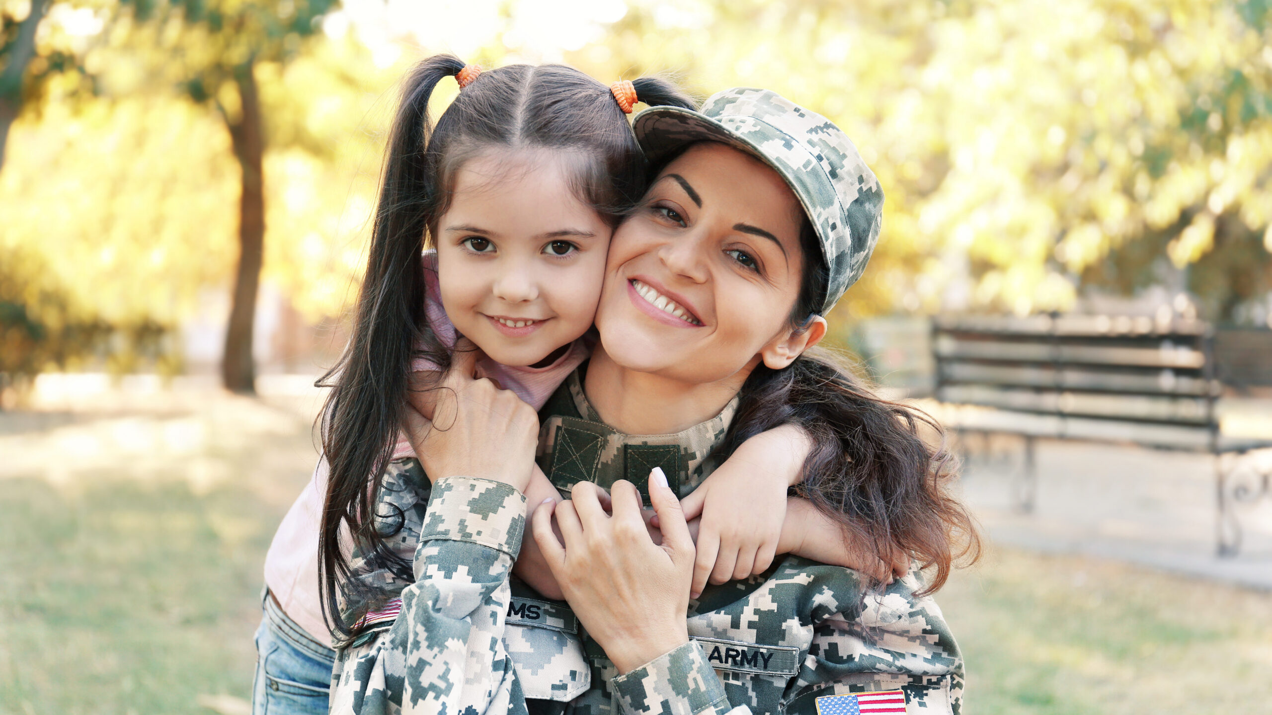 Woman in military uniform and her daughter in park
